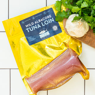 Wild Albacore Tuna Loin in packaging on tile background