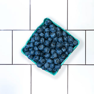 blueberries in container on tile