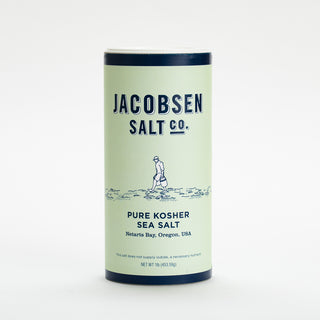 Green and navy blue container of jacobsen salt on a white background