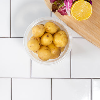 potatoes in container with cutting board and lemon garnish