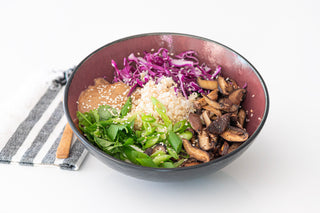 shiitake sesame brown rice bowl with dressing and scallions in a bowl 